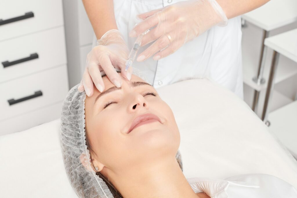 Cosmetologist makes rejuvenation injection in woman face, anti aging procedure in beauty salon